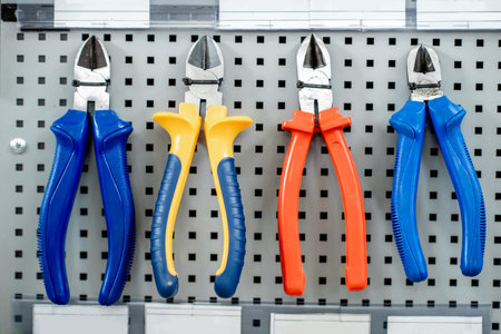Colorful pliers on the stand of building shop with tools for reparing