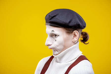 Portrait of an actor as a pantomime with white facial makeup showing expressive emotions on the...