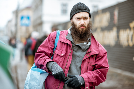 Portrait of a stylish homeless bearded beggar in the cityの写真素材