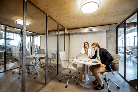 Business man and woman working in the meeting room, wide interior view on the room with transparent...