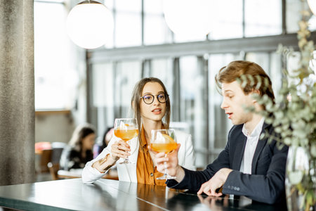 Business partners having unofficial meeting, drinking together some cocktails at the barの写真素材
