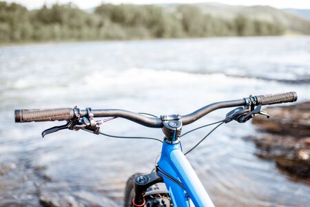 Cycle's steering wheel on the mountain river background. Concept of a freeride and off road trailsの写真素材