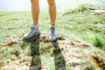 Close-up of a male legs in trekking shoes outdoors
