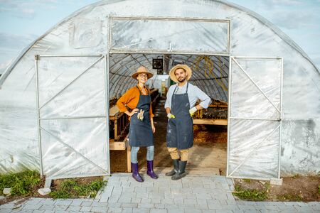 Portrait of a two well-dressed farmers or agronomists standing in front of the hothouse for snails growing on a farm outdoorsの写真素材