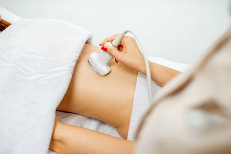 Female doctor performs ultrasound examination of a women's pelvic organs, close-up viewの写真素材