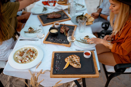 Festive dinner with delicious meals at the beautifully decorated table outdoors at dusk. View from aboveの写真素材