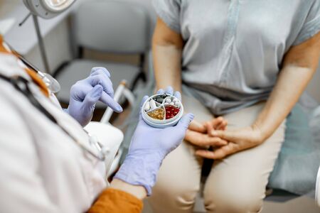 Doctor giving some medicine to a patient in the gynecological office, close-up view on the hands and pillsの写真素材