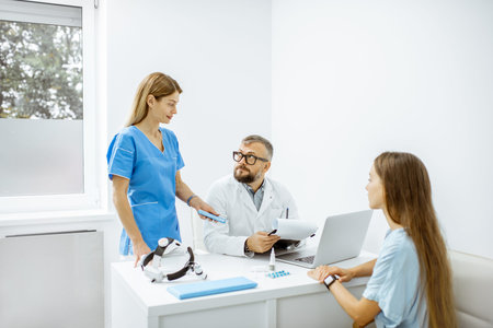 Young patient at an appointment with otolaryngologists, sitting during the consultation in the...