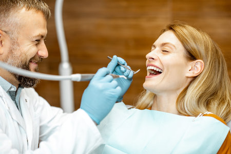 Beautiful woman as a patient with senior dentist smiling and feeling trust during a medical...