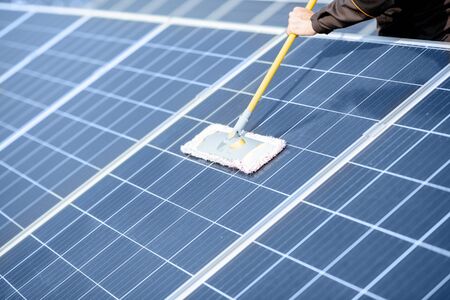 Close-up of professional cleaning of solar panels with a mob. Concept of solar power plant cleaning service