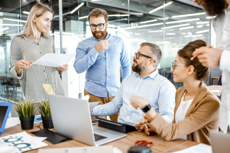 Group of diverse colleagues working in the office, having discussion or small conference on a...