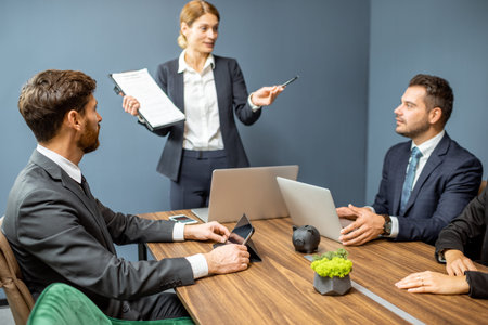Group of business people strictly dressed in the suits having an important discussion with a woman...
