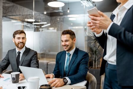 Business men stricly dressed in the suits sitting during a conference with employees in the meeting roomの写真素材