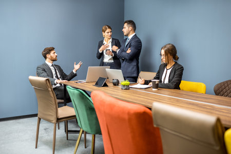 Business people having informal discussion during a coffee break in the meeting room