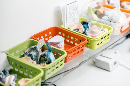 Various of artificial jaw models, impressions and dental implants on the shelves at the laboratoryの写真素材