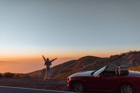 Landscape view on the roadside above the clouds with woman enjoying beautiful sunset while traveling...