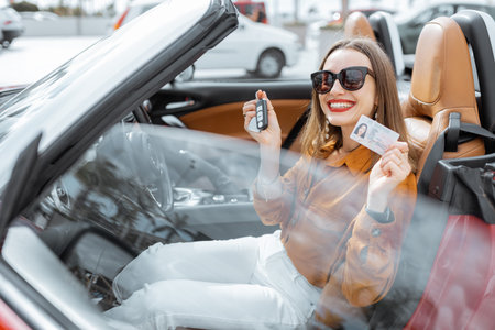 Portrait of cheerful woman feeling happy while sitting in the new sports car. Concept of a happy car...