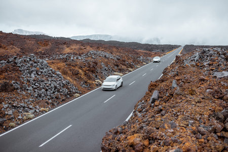 Beautiful straight road with cars on the volcanic valley on Tenerife island, Spainの写真素材