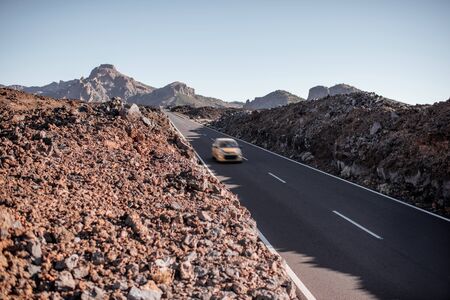 Beautiful straight road with cars on the volcanic valley on Tenerife island, Spainの写真素材