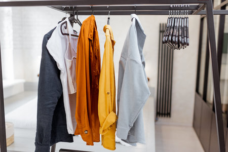 Hanger with colorful casual clothes in bedroom
