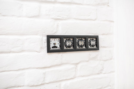 Installing electric sockets and switches on the white brick wall