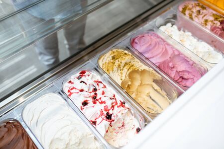 Close-up of ice cream with different flavors in the refrigerator on a shop windowの写真素材
