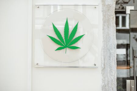 Coffee shop sign with marijuana leaf on the building wallの写真素材