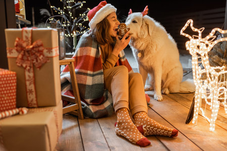 Portrait of a woman in christmas hat and plaid with her cute dog celebrating a New Year holidays on...