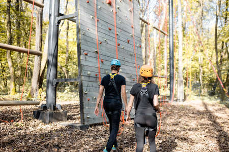 Well-equipped man and woman walking to the climbing wall outdoors, ready for the climbingの写真素材