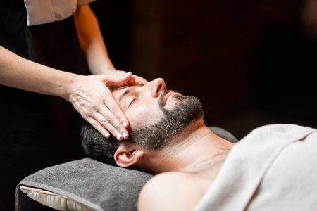 Bearded man receiving a facial massage, relaxing at Spa salon, close-upの写真素材