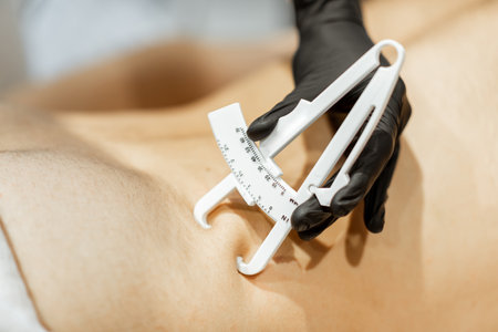 Determining the amount of sebum on male abdomen using medical caliper, close-upの写真素材