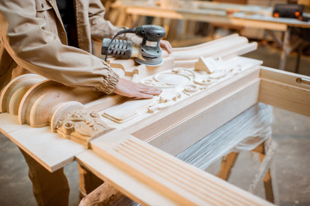 Handsome carpenter checks out carving quality of a joiners product at the carpentry manufacturingの写真素材