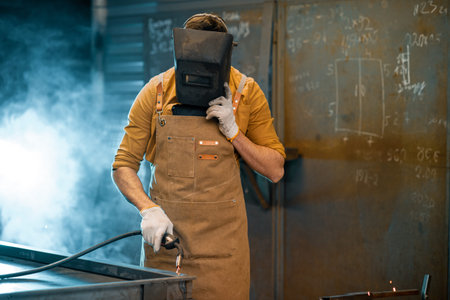 Welder working with metal at the workshop