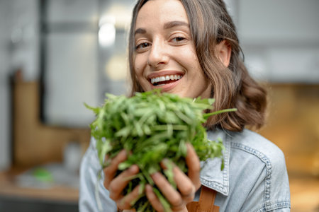 Woman with fresh arugula on the kitchen