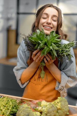 Woman with fresh spicy herbs on the kitchenの写真素材