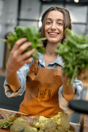 Woman with fresh greens on the kitchen