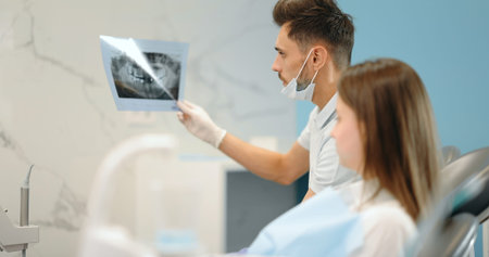 Dentist showing x-ray of a jaw for a young patient