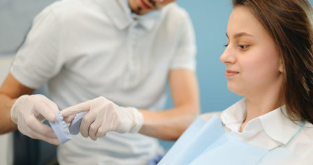 Dentist showing jaw model for a young patient