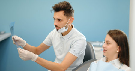 Dentist showing x-ray of a jaw for a young patient