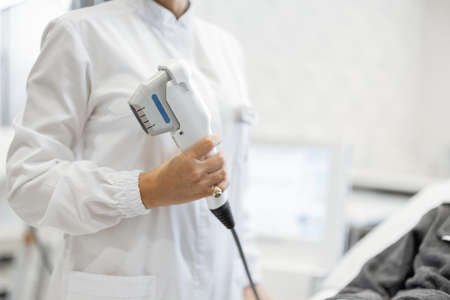 Cosmetologist in white robe with patient in cosmetology salonの写真素材