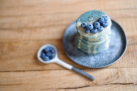 Blue pancakes with blueberry and caramel souse on vintage plate.の写真素材