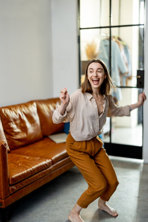 Woman jumps from the sofa to the floorの写真素材