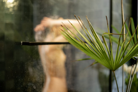Woman taking shower relaxing under warm water