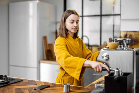 Woman making coffee in the morning at homeの写真素材