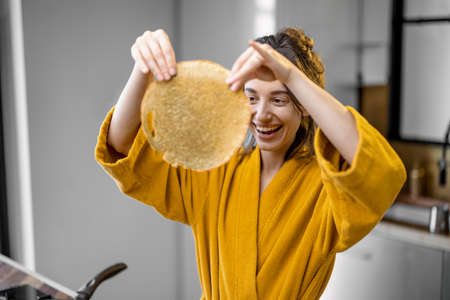Woman cooks pancakes for breakfastの写真素材
