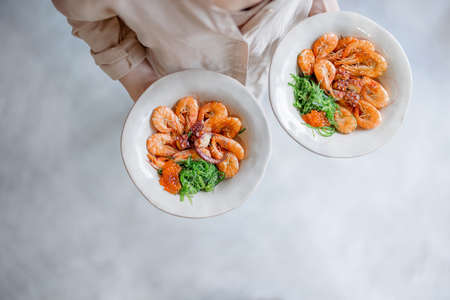 Woman carrying delicious seafood dishes, top viewの写真素材