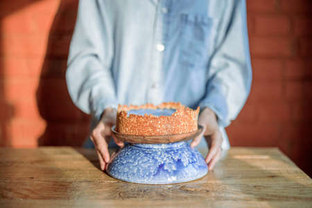 Woman putting yummy cheesecake on a dinner tableの写真素材