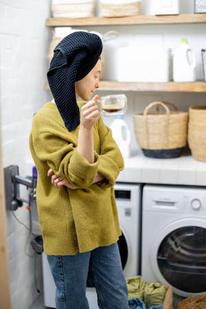 Housewife in the laundry room at homeの写真素材