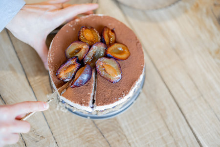 Cheesecake decorated with plums on the tableの写真素材