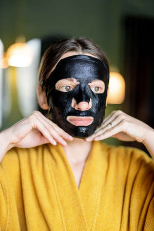 Woman with cleansing black mask on her faceの写真素材